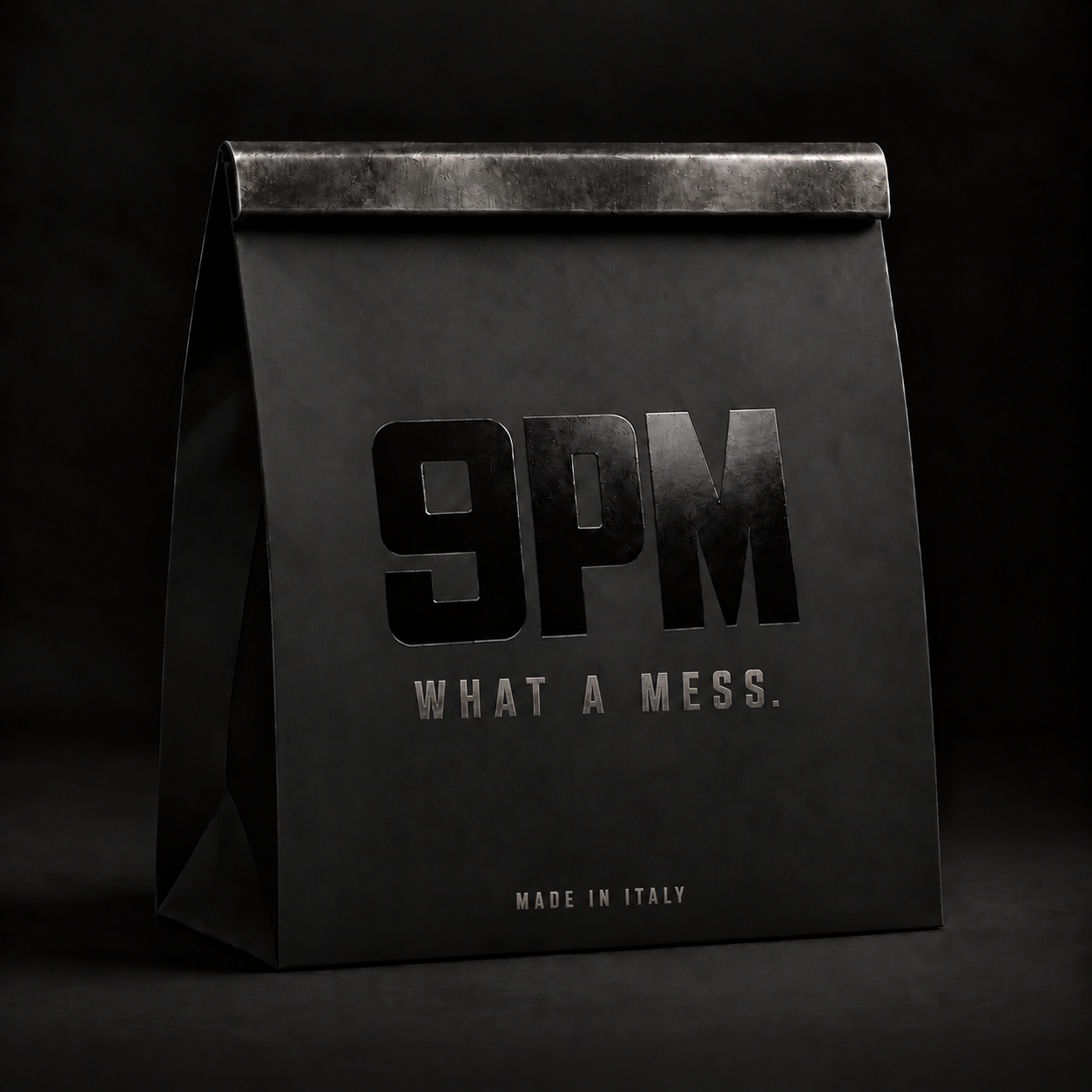 Black 9 PM takeout bag with brushed steel closure and What a Mess branding