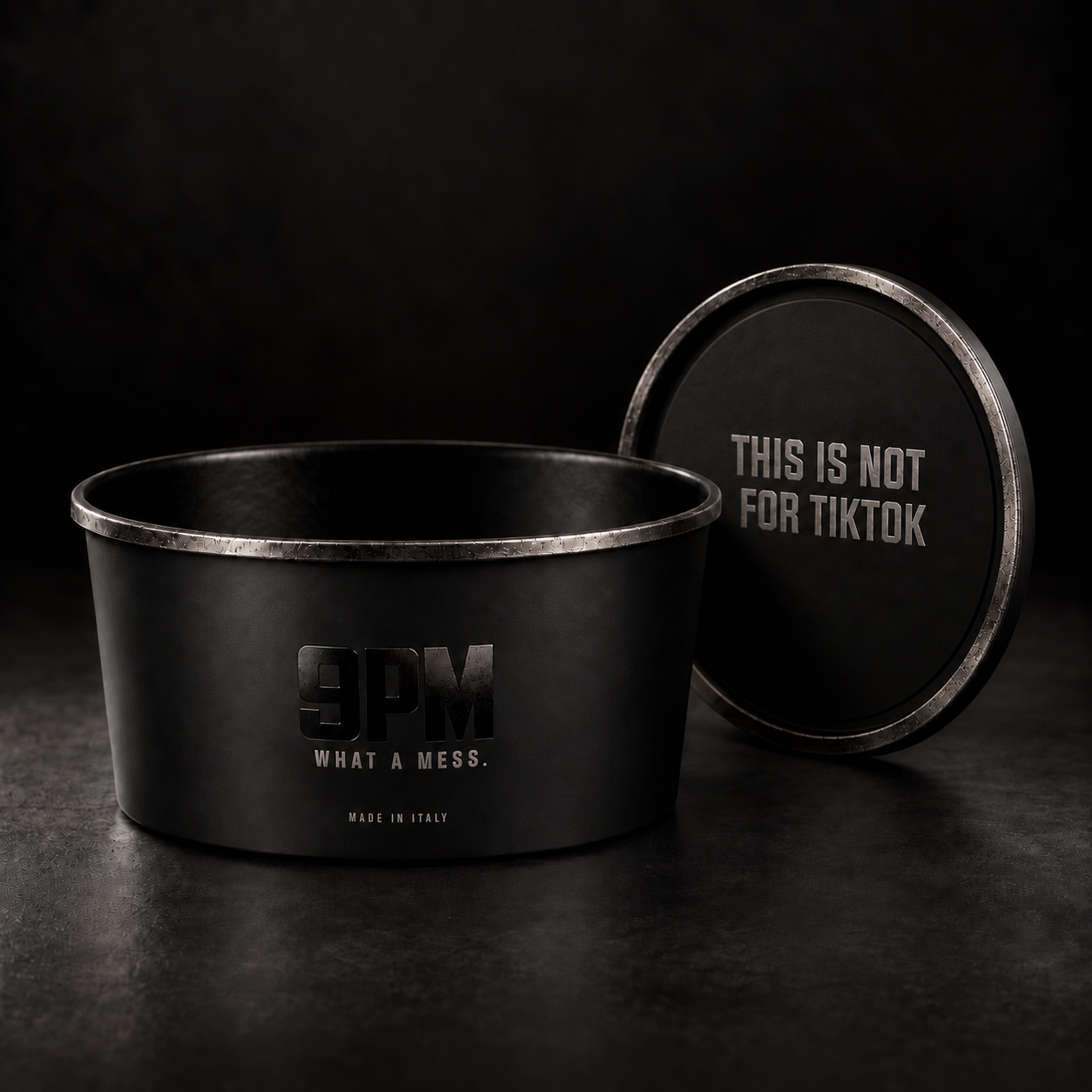 Black 9 PM bowl and lid with brushed steel rims and embossed brand statements